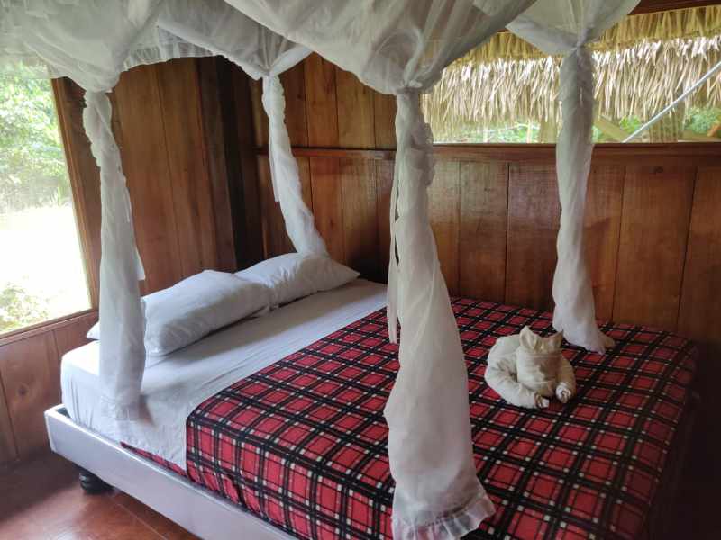 A Queen bed in a triple room at Cuyabeno Kichwa Lodge.